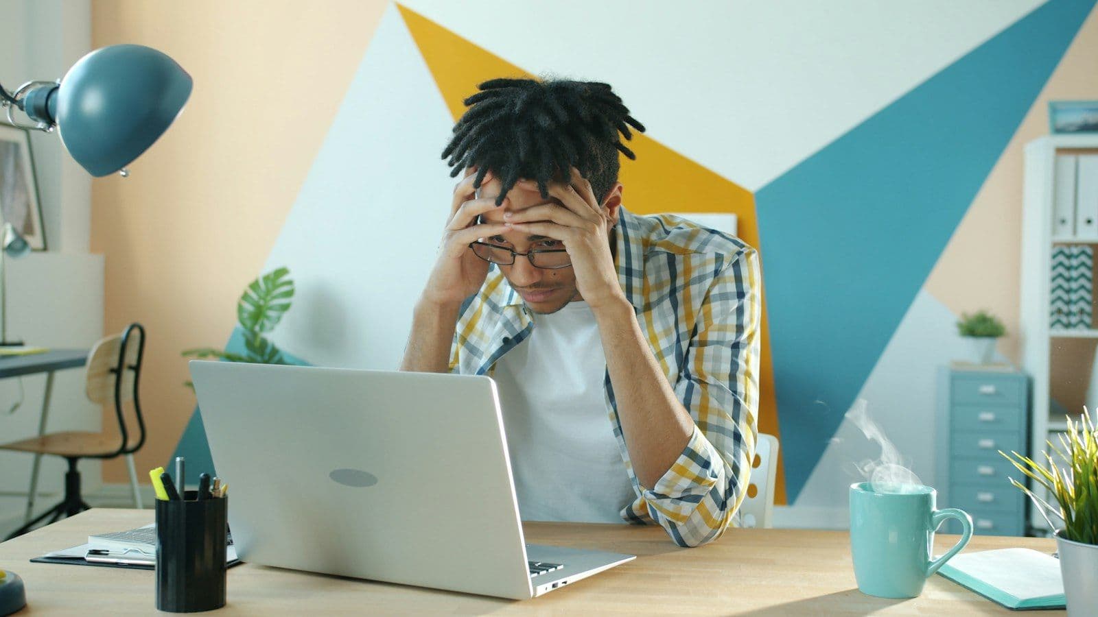 A frustrated person holding their head while looking at a laptop screen — Website red flags that cost Houston small businesses customers