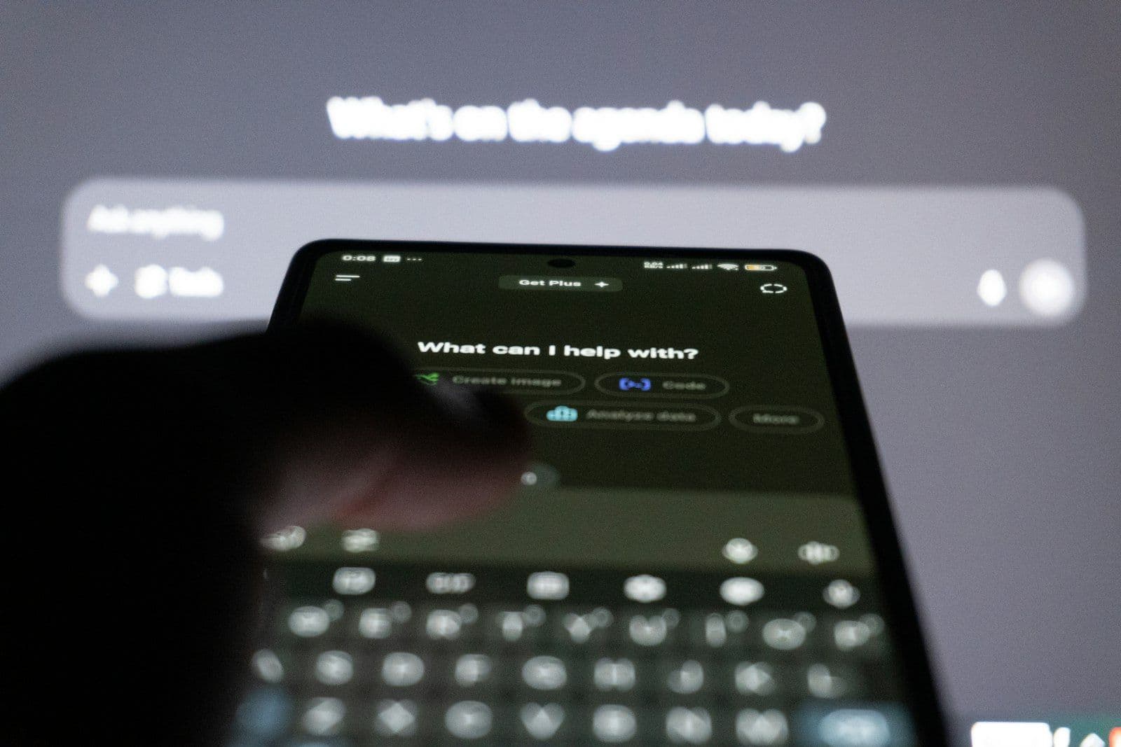 A hand holding a smartphone showing an AI assistant's chat prompt — How to show up when someone asks ChatGPT or Google for a plumber