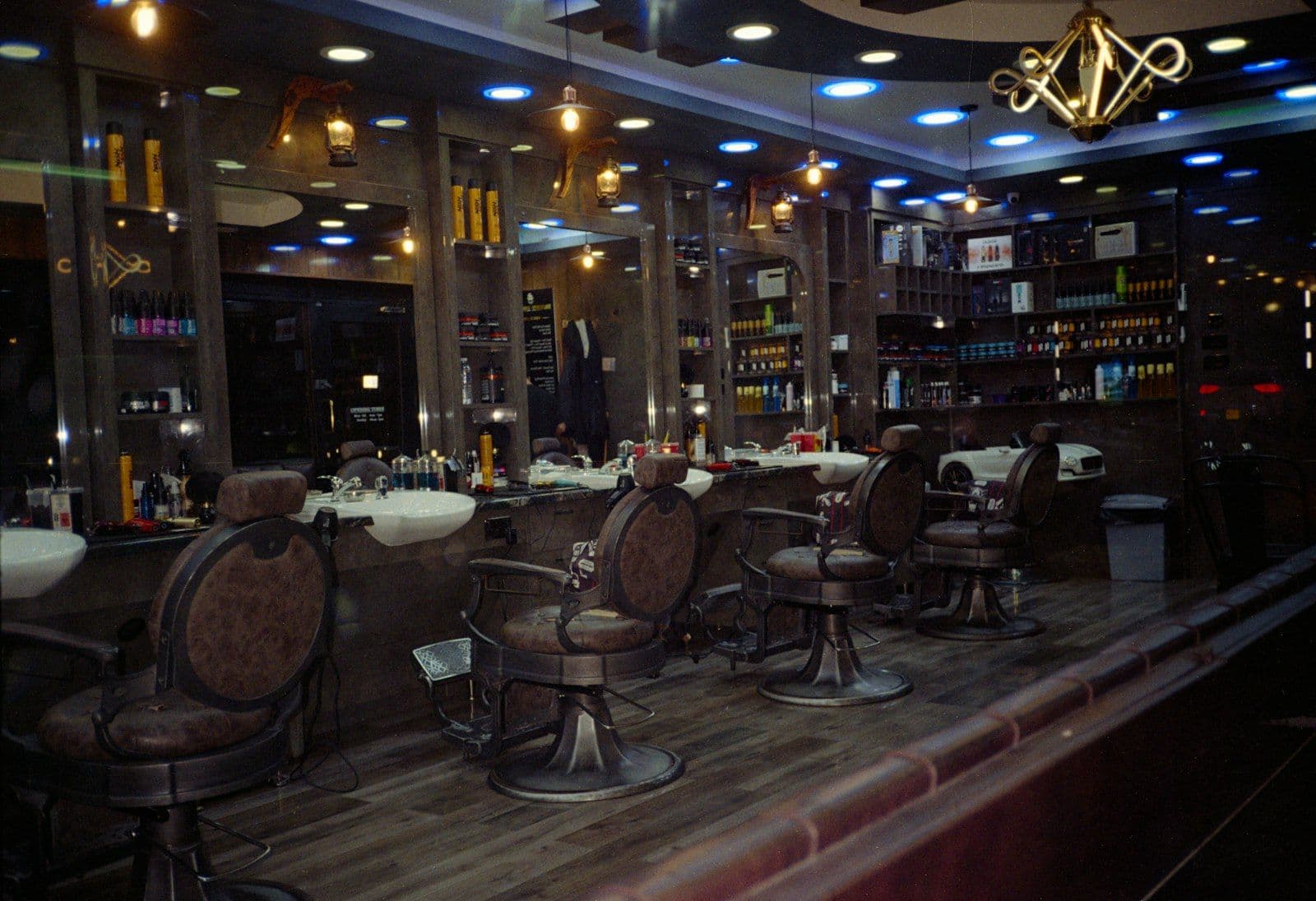 A row of vintage leather barber chairs in a dimly lit, mirrored barbershop — What barbershops and salons actually need from a website